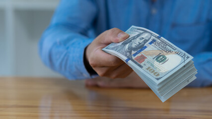 US dollar banknotes in the hands of many businessmen, successful business and wealth. with the concept of finance and expenditure