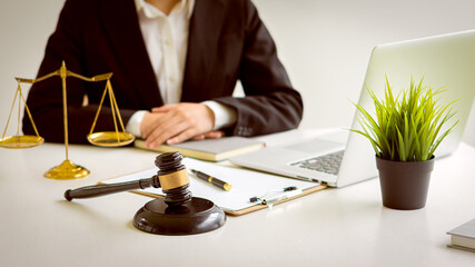 Judge's hammer and scales of justice with lawyers working in the concept office of the legal advisor.