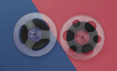 Audio magnetic tape. Two Film reel on colored background. Top view. Retro style. 80s