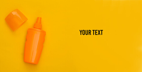 Sunblock bottle on a yellow background. Skin protection. Beach vacation. Copy space. Top view