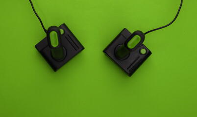 Retro joysticks on green background. Gaming, video game competition. Top view
