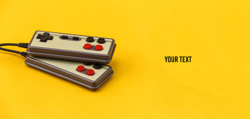 Two retro gamepads on yellow background. Gaming, video games. © splitov27