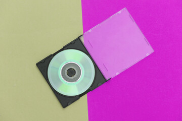 Compact disc with box on colored background. Top view, minimalism