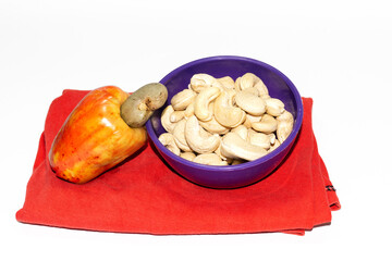 cashew nuts in bowl with cashew apple isolated on white background