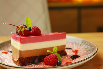Piece of tasty mousse cake with   fresh berries on plate  