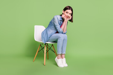 Full size profile side photo of young attractive girl happy positive smile sit stool isolated over green color background