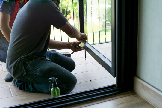 Hands of worker repairs the door frame