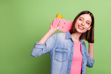 Photo of funny brunette hair millennial lady hold skate look empty space wear jeans jacket isolated on green color background