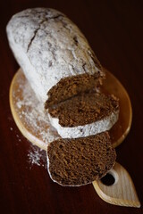 Sliced black bread on the wooden board at dark table