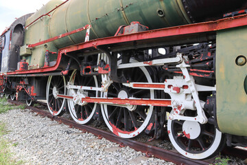 Fototapeta na wymiar Old large iron train wheels, bogies are on the tracks for an industrial steam locomotive.
