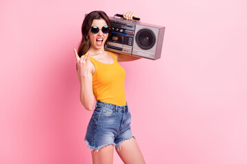 Photo of rude funky lady dressed yellow tank-top dark glasses holding boom box showing hard rock...