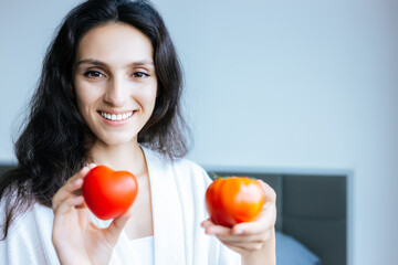 Healthy eating concept Beautiful young woman holding heart and vegetable Attractive beauty girl looks at camera with smile face Beautiful female get diet She lose weight It is good for beauty skin