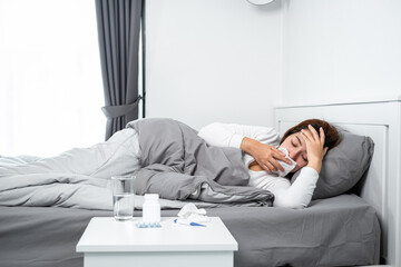 Asian woman using tissue cover your mouth to cough, sneeze and touching forehead while feeling sick