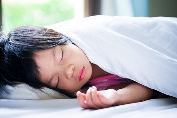 A 4-5 year old girl is resting. Asian children are sleeping during the day.