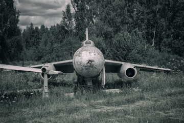 Old rusty abandoned airplane in the open air. Remnants of the former Soviet power. A military plane rusts in the forest.