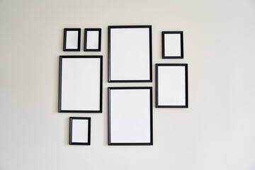 Different size framed photos hanging on the gray wall. Mockup.