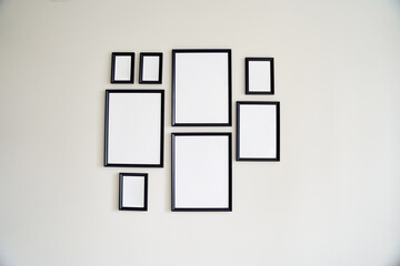 Different size framed photos hanging on the gray wall. Mockup.