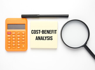 Calculator, magnifying glass, pen and notepad wirtten Cost-Benefit Analysis. cost-benefit analysis...