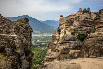 Fototapeta na wymiar Meteora, Greece, monastery on top of the mountain hill. Scenery summer view with cloudy sky.