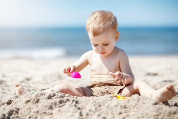 Boy plays with sand by the sea
