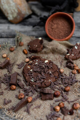 Chocolate cookies with hazelnuts , cocoa and pieces of dark chocolate on the rustic kitchen table