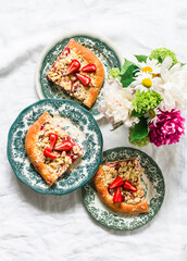 Pieces of yeast dough strawberry rhubarb sweet pie with crumbs on a light background, top view