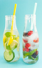Two glass bottles with cocktails or lemonades on a blue background