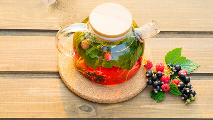 Freshly brewed berry tea on wooden background. Image with selective focus