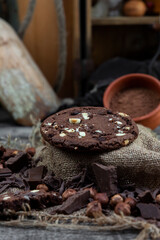 Chocolate cookies with hazelnuts , cocoa and pieces of dark chocolate on the rustic kitchen table