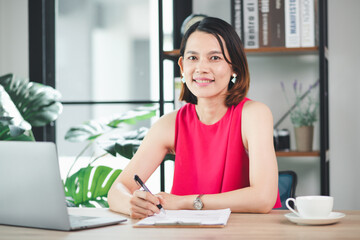 Happy beautiful woman working on wooden table with laptop and coffee cup. at work at home work from home concept
