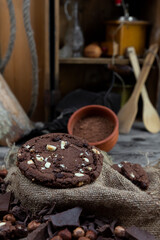 Chocolate cookies with hazelnuts , cocoa and pieces of dark chocolate on the rustic kitchen table