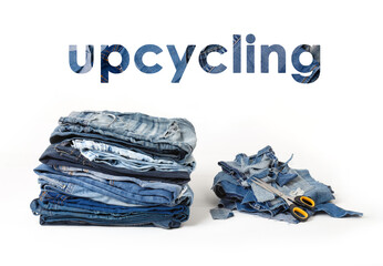 Concept of upcycle old denim garbage. Recycling old jeans. Stack of old blue jeans, cut pieces ready for recycling and scissors on white background. Pile of discarded old blue jeans. Zero waste - 443696647