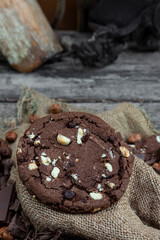 Chocolate cookies with hazelnuts , cocoa and pieces of dark chocolate on the rustic kitchen table