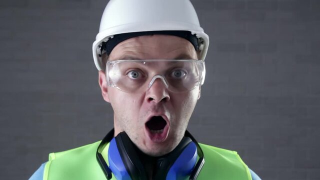 Young handsome man wearing handyman uniform shouting. Afraid and surprised or shock with open mouth. Сonstruction or panic concept