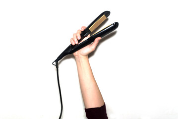 Detail of a hand holding a flat iron isolated on a white background. Hair straightener