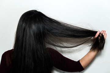 Woman from behind running her hand through her beautiful long shiny black hair