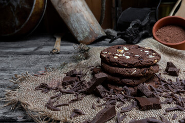 Chocolate cookies with hazelnuts , cocoa and pieces of dark chocolate on the rustic kitchen table