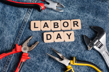 top view of cubes with labor day lettering near various tools on denim cloth