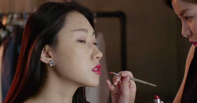 Makeup artist applying makeup on model,4K