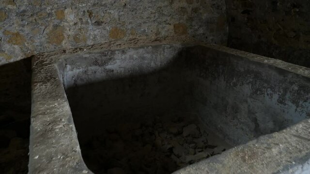 Coarse grained stone freezer in an old sinister basement made of red bricks in Ukraine  