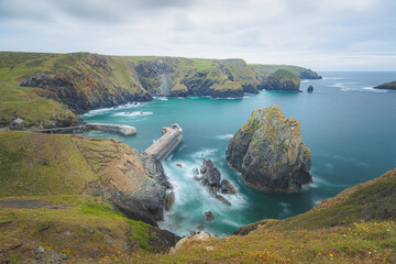 View of moody seascape landscape Mullion Cove on a summer day on the Lizard Peninsula in West Cornwall, England, UK. - obrazy, fototapety, plakaty