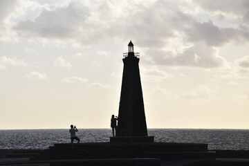Silueta de faro con dos personas