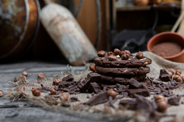 Chocolate cookies with hazelnuts , cocoa and pieces of dark chocolate on the rustic kitchen table