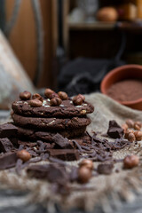 Chocolate cookies with hazelnuts , cocoa and pieces of dark chocolate on the rustic kitchen table