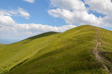 Hiking pathway along the grassy slopes of Borzhava ridge. The hilly landscape is perfect for hiking. Carpathian mountains, Ukraine