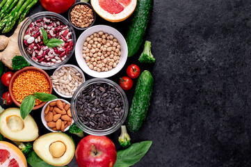 Healthy food. Fresh fruits, vegetables and seeds on a stone background with copy space for your text