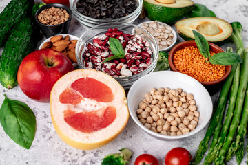 Fresh fruits, vegetables and seeds. Healthy food on a light stone background.