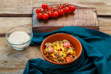 Risotto with mushrooms in a plate on a wooden background on a blue napkin and ingredients.