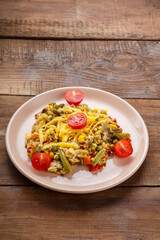 Risotto with mushrooms in a beige plate on a wooden background.