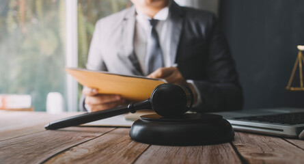Justice and law concept.Male judge in a courtroom with the gavel, working with, computer and...